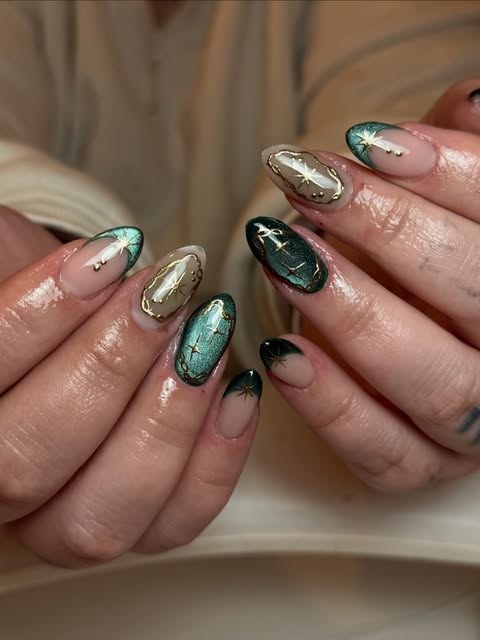 Almond nails in teal cat-eye gel with gold chrome stars and black French tips