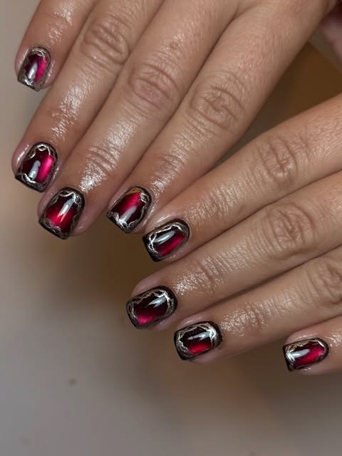 Short nails in glossy red and black cat-eye gel with white crackle line art